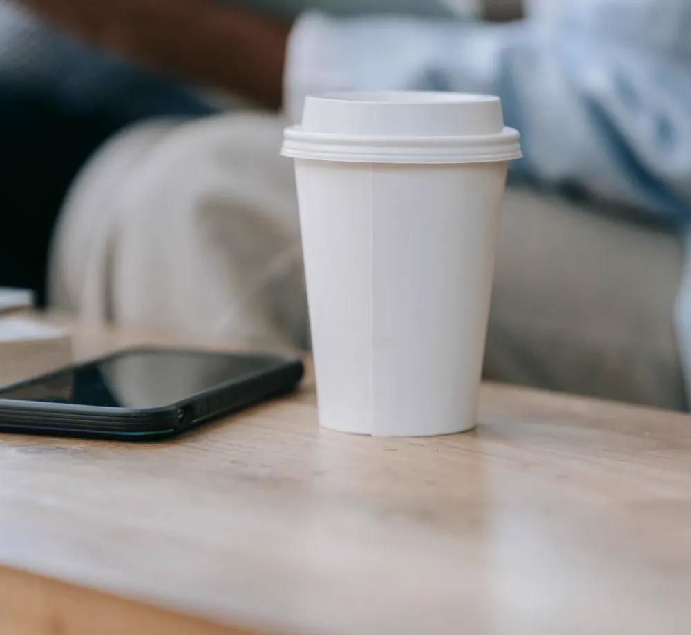 Illustrative scene: a phone set face down beside a cup of coffee